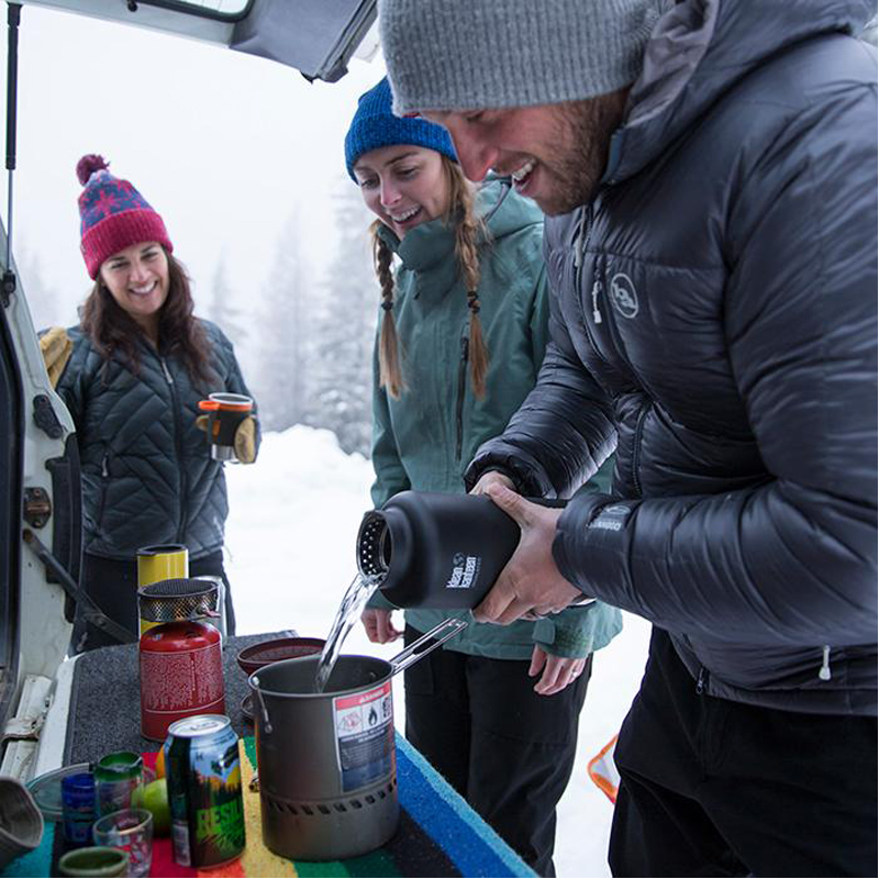 Photo of friends together on a snowy day using their TKWide Insulated Water Bottle from Klean Kanteen on EarthHero.