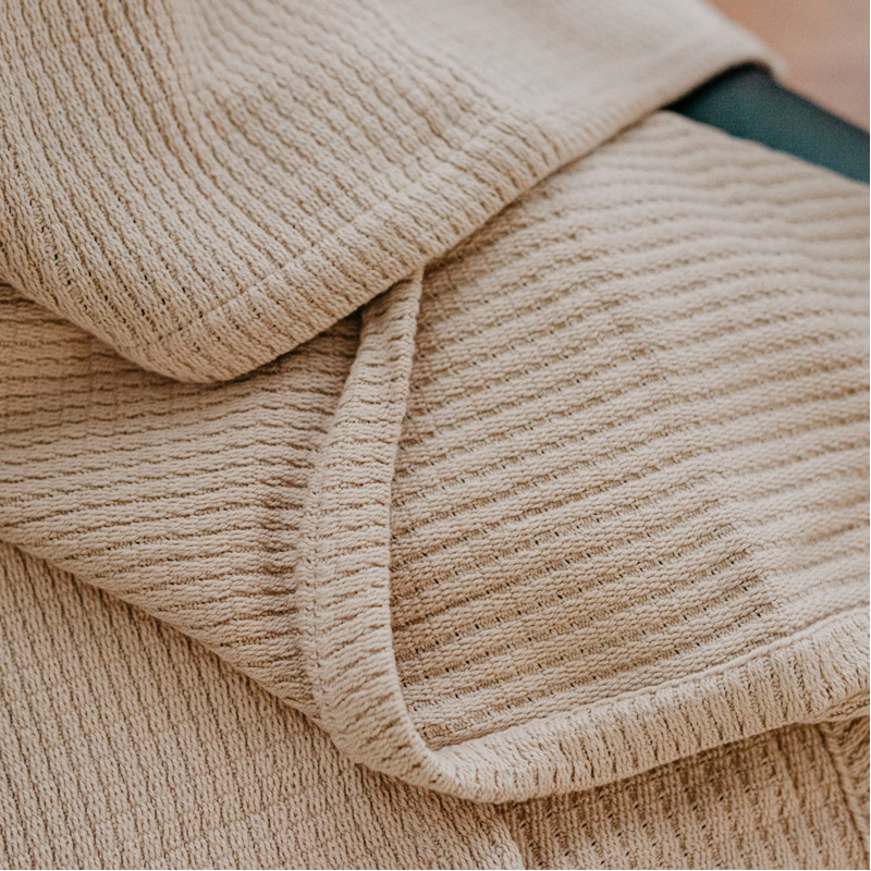 A beige blanket from Grund called Sea Throw Blanket on EarthHero